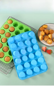 Close-up of 24-cup silicone muffin mold showing front and back textures on cooling rack