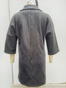 Vue arrière d'un manteau en laine gris foncé avec col à revers sur un mannequin