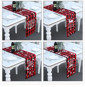 Detail van de rood-zwarte kersttafelloper met ruitpatroon en feestelijke motieven