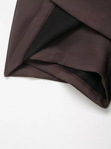 Detail of dark brown mini skirt pants with fine plain weave and precise hem stitching