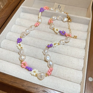 Detail of beaded flower necklace with baroque pearls and golden lobster clasp