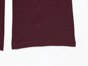 Detailed macro view of the double-stitched hem on burgundy slim fit suit trousers
