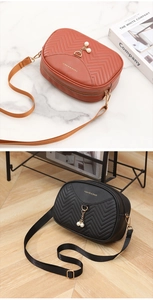 Detail of chevron pattern PU leather bags with elegant gold lettering and pearl pendants