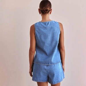 Back view of a trendy two-piece blue denim set with sleeveless vest and matching shorts