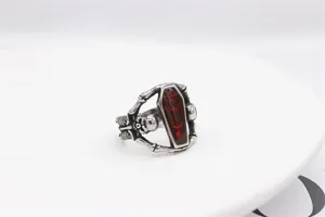 Macro detail of gothic skull ring with red coffin inlay and carved ribcage details