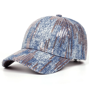 Close-up of blue washed denim baseball cap with rose gold sequins on a white background