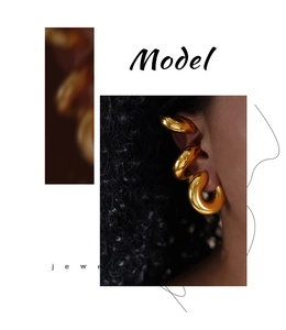 Detailed view of three polished gold geometric hoop ear clips worn on the ear