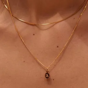 Double-layered gold necklace set with minimalist chains and a letter R oval pendant