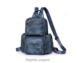 Detail view of the vintage blue denim backpack with multi-pocket and bronze zippers