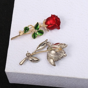 Detail of red rose brooch showing matte petals, enamel leaves and secure back pin
