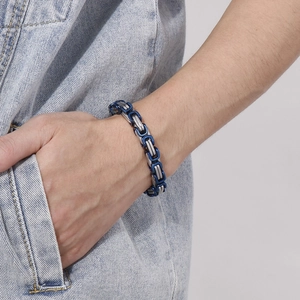 Detailed view of blue and silver Byzantine stainless steel chain bracelet on wrist