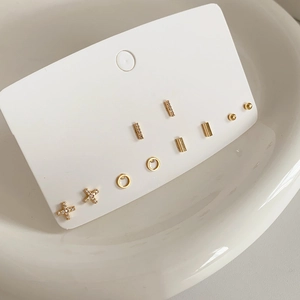 Detailed set of six pairs of gold plated geometric stud earrings on white display card