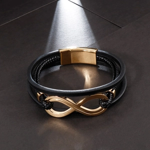 Dettaglio del bracciale in pelle nera con simbolo infinito dorato e chiusura magnetica
