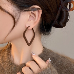 Brown rhombus flocked earrings worn by a model for a stylish autumn winter look