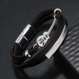 Macro shot of men's leather multi-layer bracelet featuring silver guitar charm and magnetic clasp