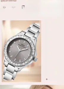Detail of silver steel watch with grey brushed dial and zircon-set bezel against pink backdrop