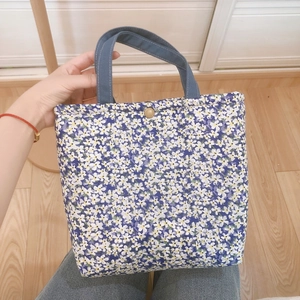 Floral canvas lunch tote bag with thick handles and vintage button closure in dark blue
