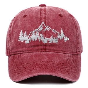 Close-up of white mountain and forest embroidery on a burgundy washed baseball cap