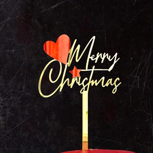Detailed view of Merry Christmas gold acrylic cake topper with red heart and stars