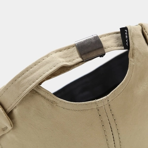 Close-up of khaki cotton beanie with metal buckle adjustment and NEW label detail