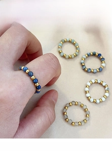 Detailed view of elastic beaded rings with natural stone and golden metal spacers