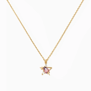 Macro shot of 18K gold star pendant necklace with gradient purple gemstone and zircons