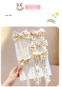 Detail showing five-piece set of polka dot hair clips with long ribbon streamers