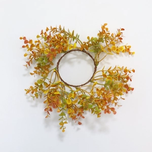 Close-up of autumn eucalyptus candle ring with orange and yellow gradient foliage
