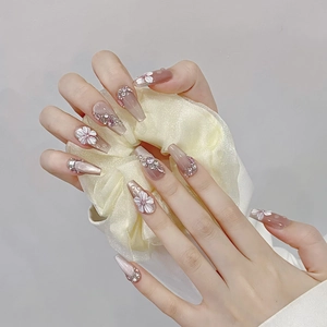 Handgefertigte Press-on-Nägel mit 3D-Blumen und funkelnden Strasssteinen auf Nude-Rosa