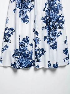 Détail de la jupe midi en coton montrant l'imprimé floral bleu et blanc et l'ourlet