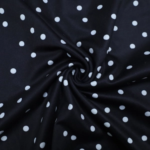 Détail du tissu à pois noir et blanc avec une texture froncée douce et un tombé élégant