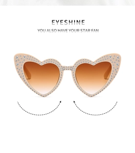 Close-up of pink heart-shaped sunglasses with white rhinestones and star patterns