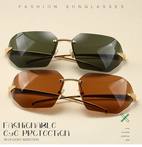 Detail view of rimless sunglasses with dark green and amber lenses on gold metal frames
