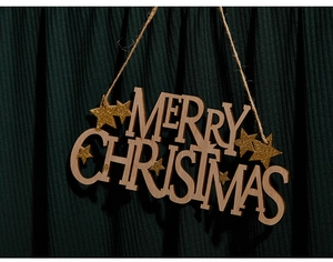 Close-up of wooden Merry Christmas hanging sign with gold glitter on green fabric