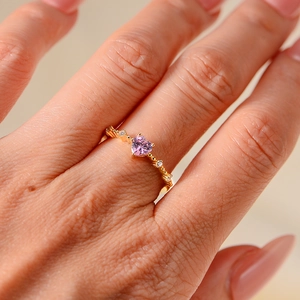 Detail of s925 silver ring with pink heart zircon and small diamonds on gold band