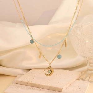 Detail view of gold double layer necklace with blue beads and celestial charms on silk