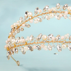 Close-up of golden bridal headband featuring handmade crystal leaves and pearls detail
