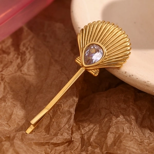 18K gold plated stainless steel scallop hair clip with pear-cut zircon on brown paper