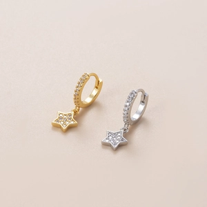 Detailed view of gold and silver hoop earrings with shimmering zircon star pendants