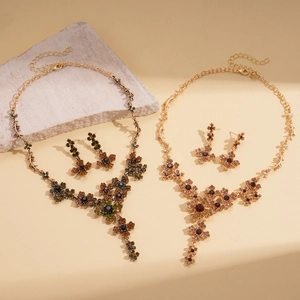 Detail shot of vintage floral rhinestone necklace and earrings set in antique gold finish