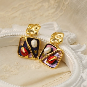 Makroaufnahme französischer Vintage-Ohrringe mit Emaille und Perlen in Gold-Optik