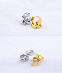 Detailed macro view of irregular C-shaped gold and silver non-piercing ear cuffs