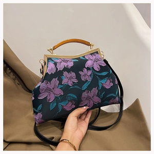 Detail of elegant floral embroidery on dark cheongsam handbag with brown resin handle