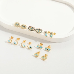 Golden evil eye earring set featuring sunburst and crescent moon designs with blue zircon