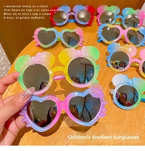 Macro view of children's gradient sunglasses with heart and bow shaped frames