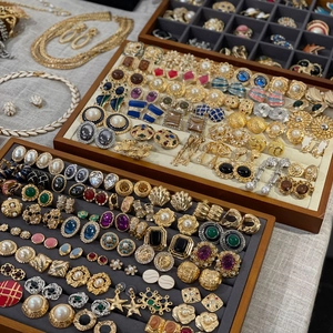 Collection of vintage gold and silver earrings with pearls in wooden display trays