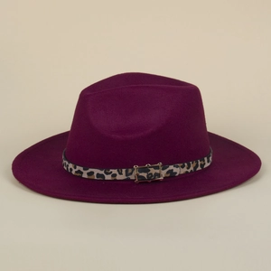 Detail of burgundy fedora hat featuring leopard print band and golden buckle