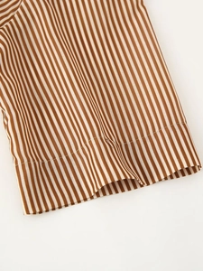 Close-up of sleeve cuff on striped shirt dress featuring brown and white vertical patterns