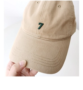 Macro view of khaki washed cotton baseball cap with green number 7 embroidery detail