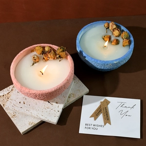 Handmade scented candle in pink and blue ceramic bowls with dried rose petals decor